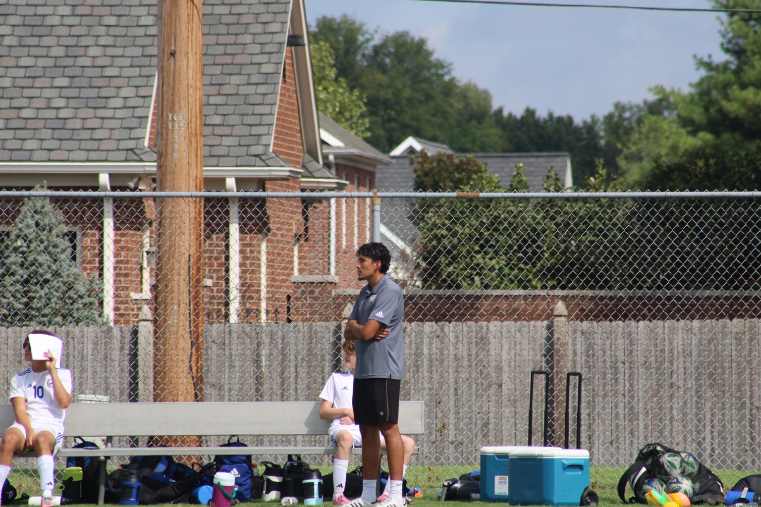 Coach Alex watching the game beside the team bench